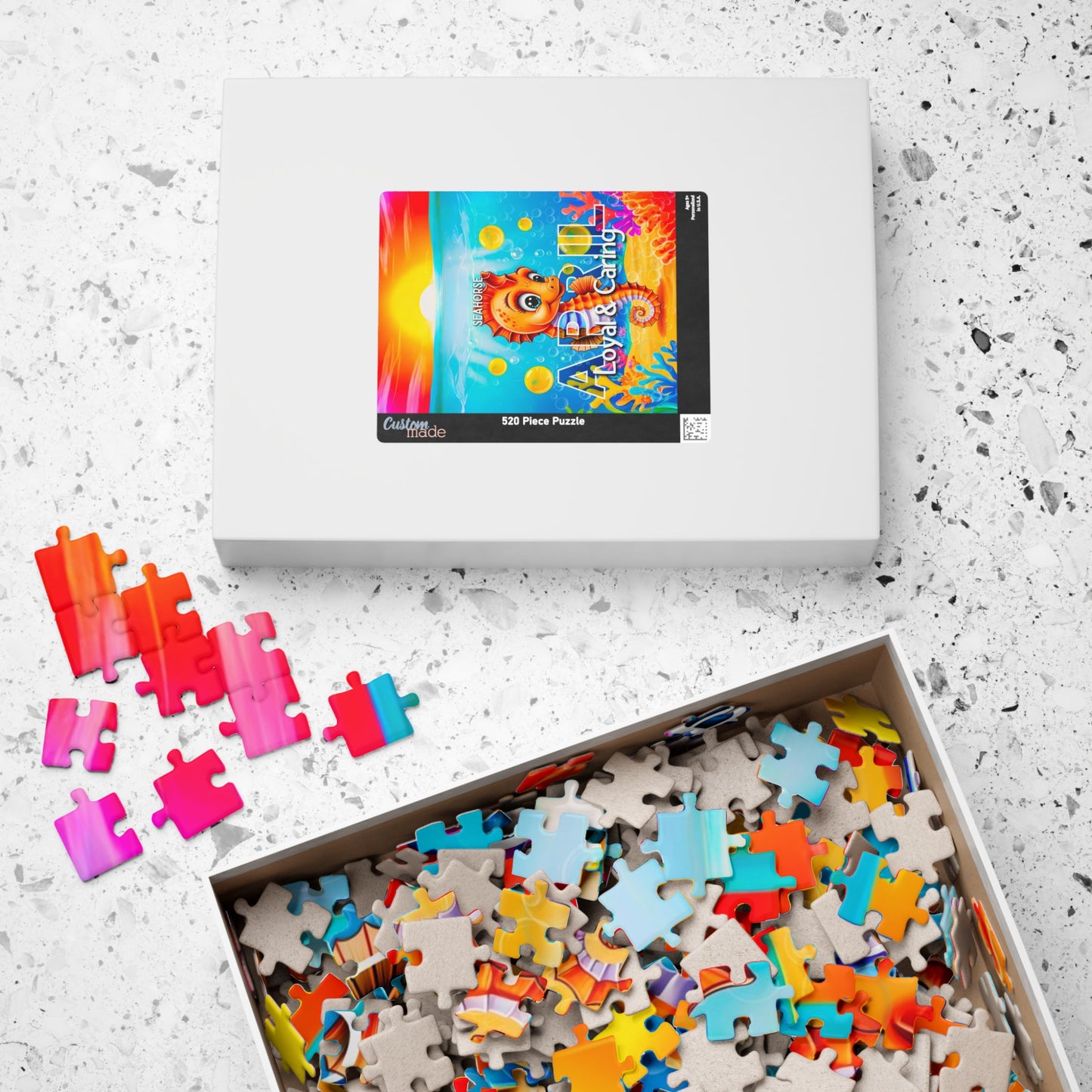 Kids birth month puzzle with colorful scattered pieces in an open white box on a speckled surface