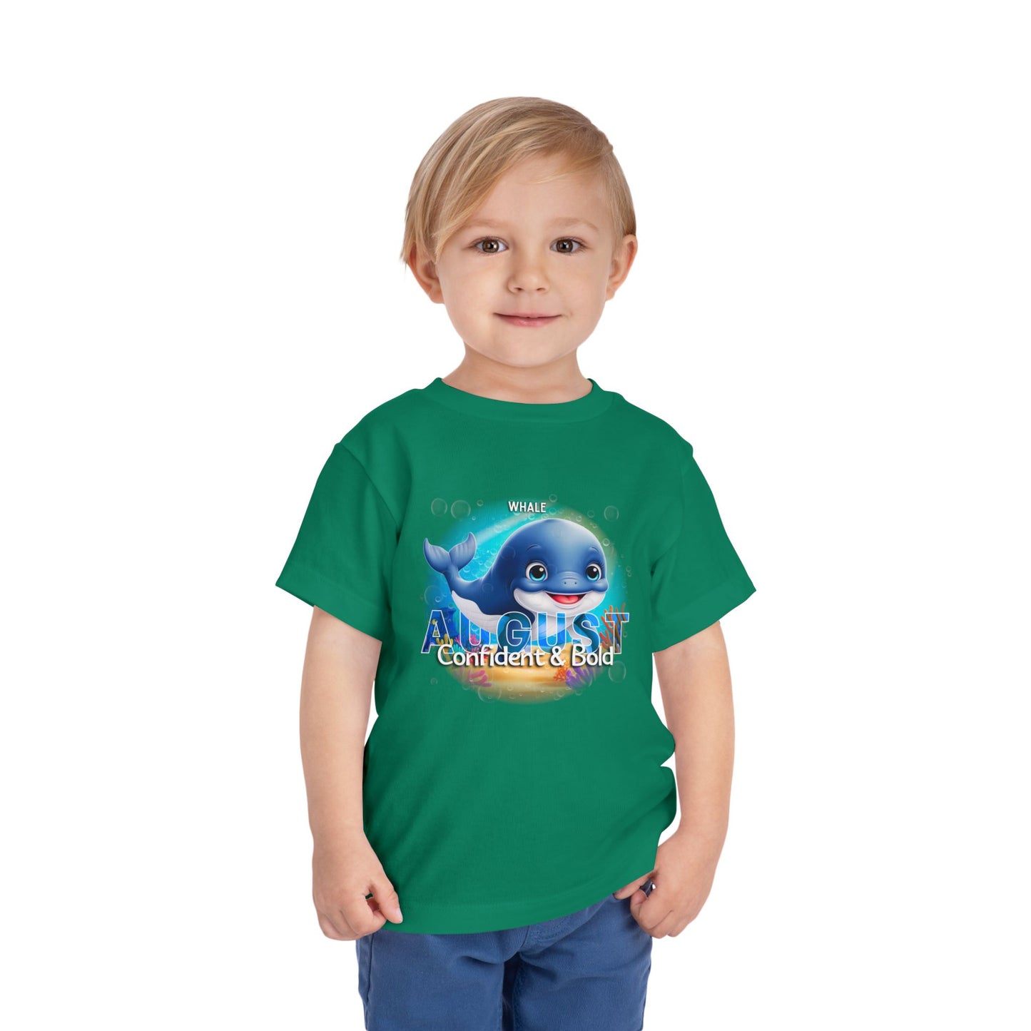 Green kids birth month tshirt with August design featuring a whale and bold text worn by a smiling child