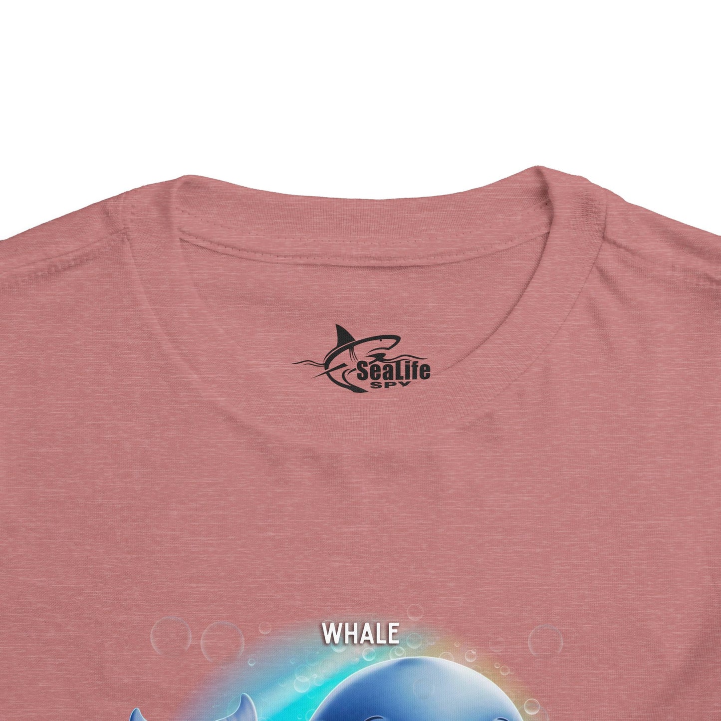 Kids birth month tshirt with whale design on pink fabric close-up
