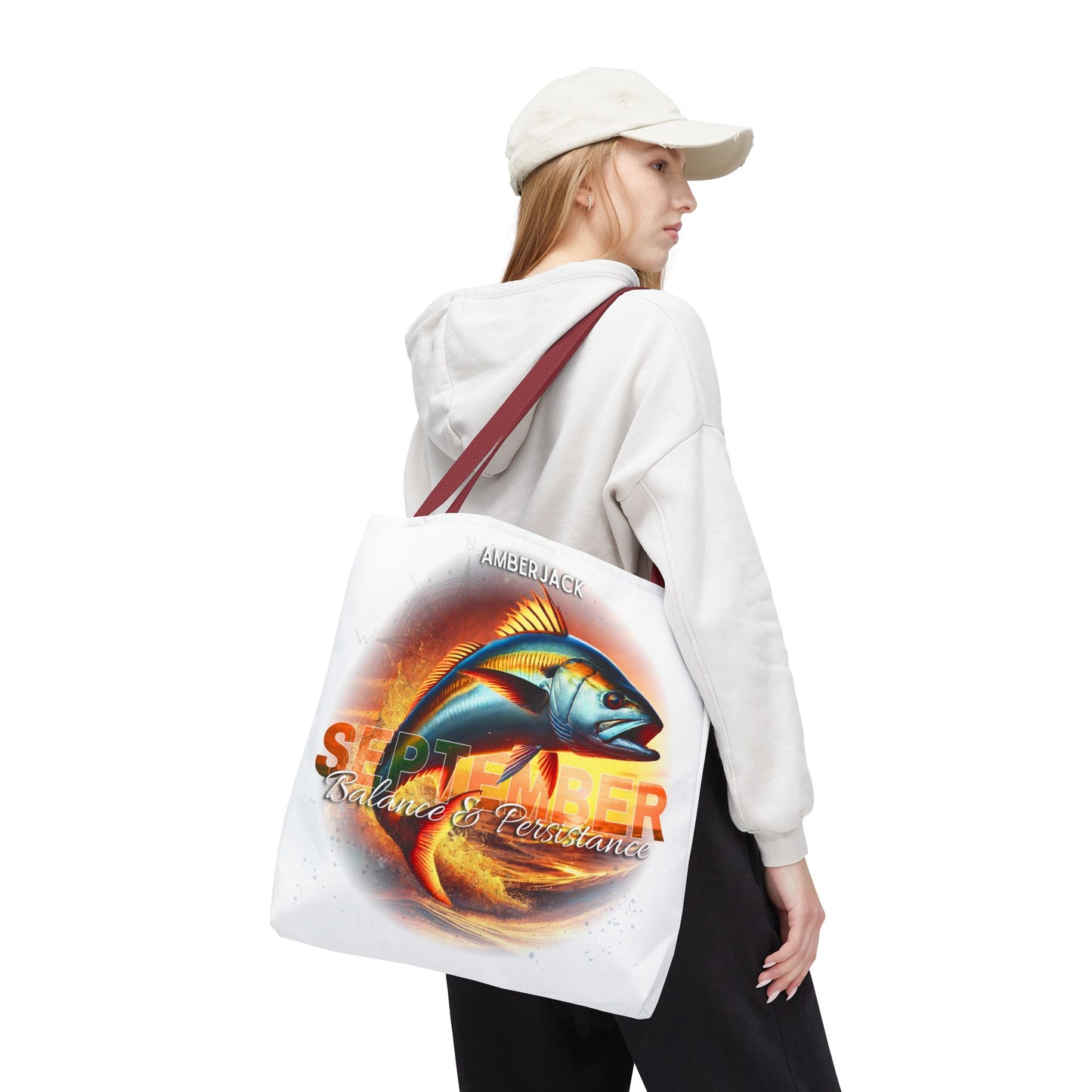 Birth month beach tote with colorful September fish design carried by woman in white hoodie