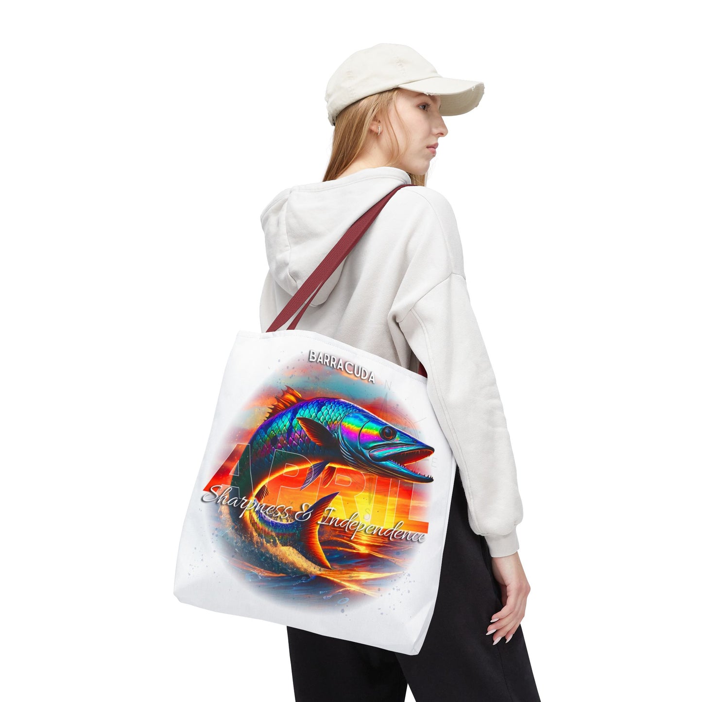 Birth month beach tote with colorful barracuda fish graphic carried by woman in white hoodie and cap