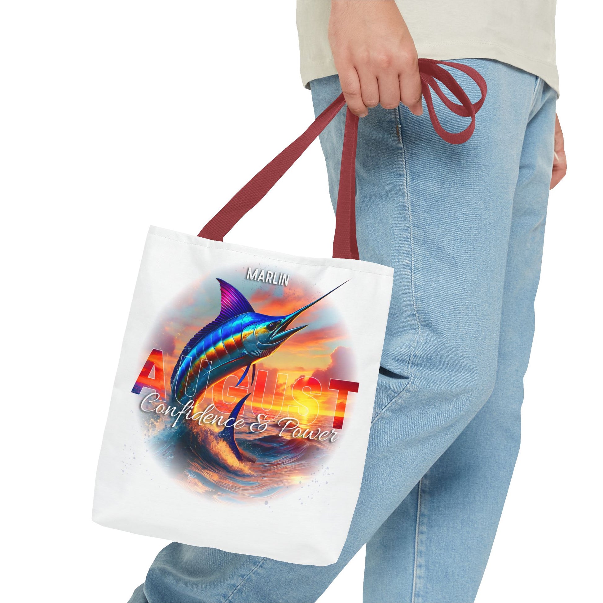 Person holding birth month beach tote with August marlin design and red handles
