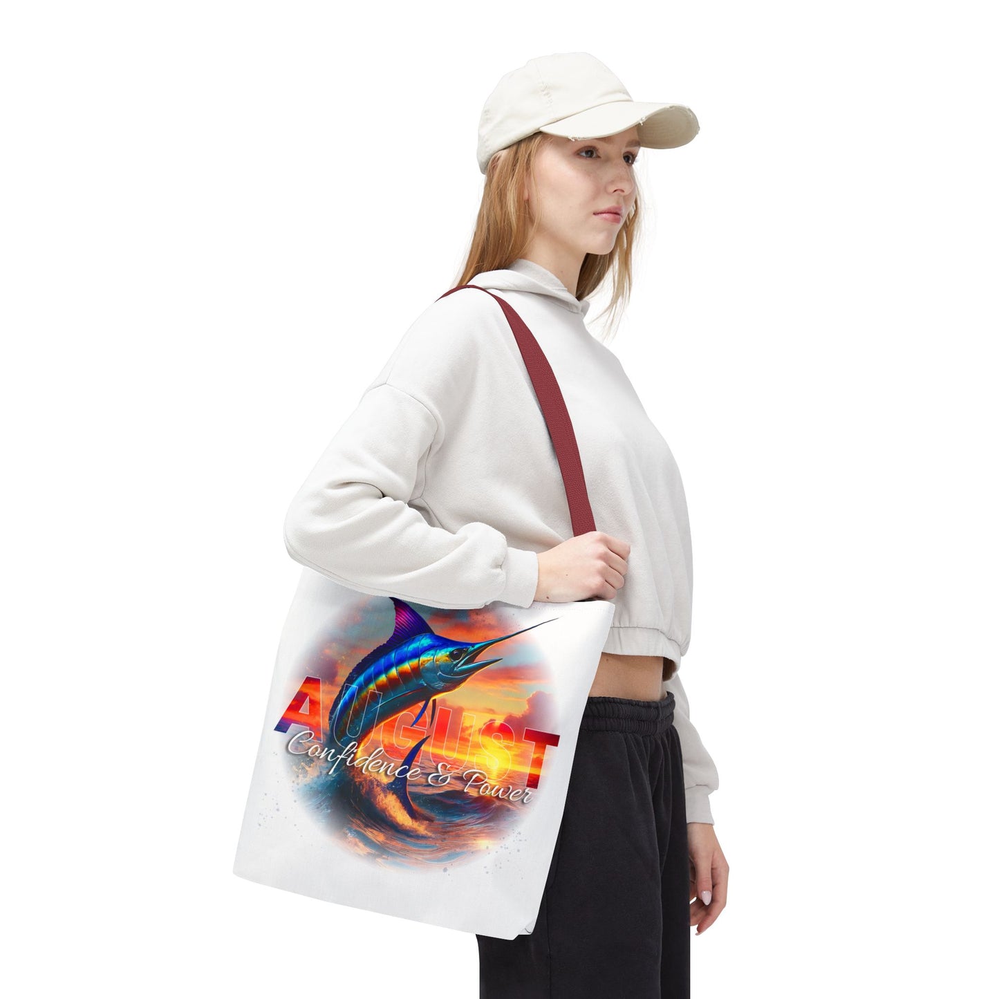 Woman carrying birth month beach tote with August design and marlin fish artwork