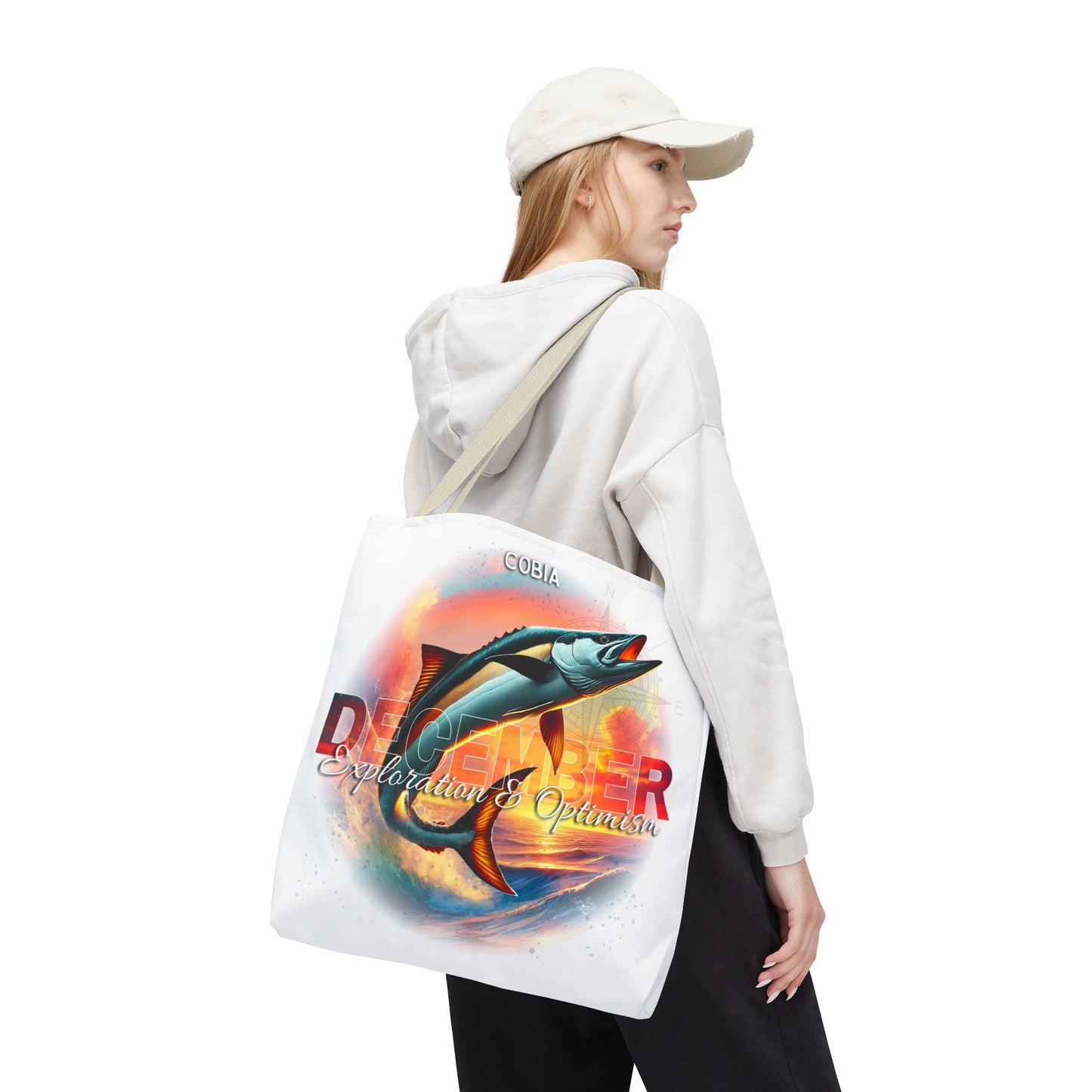Woman wearing a white hoodie carrying a birth month beach tote with colorful fish design