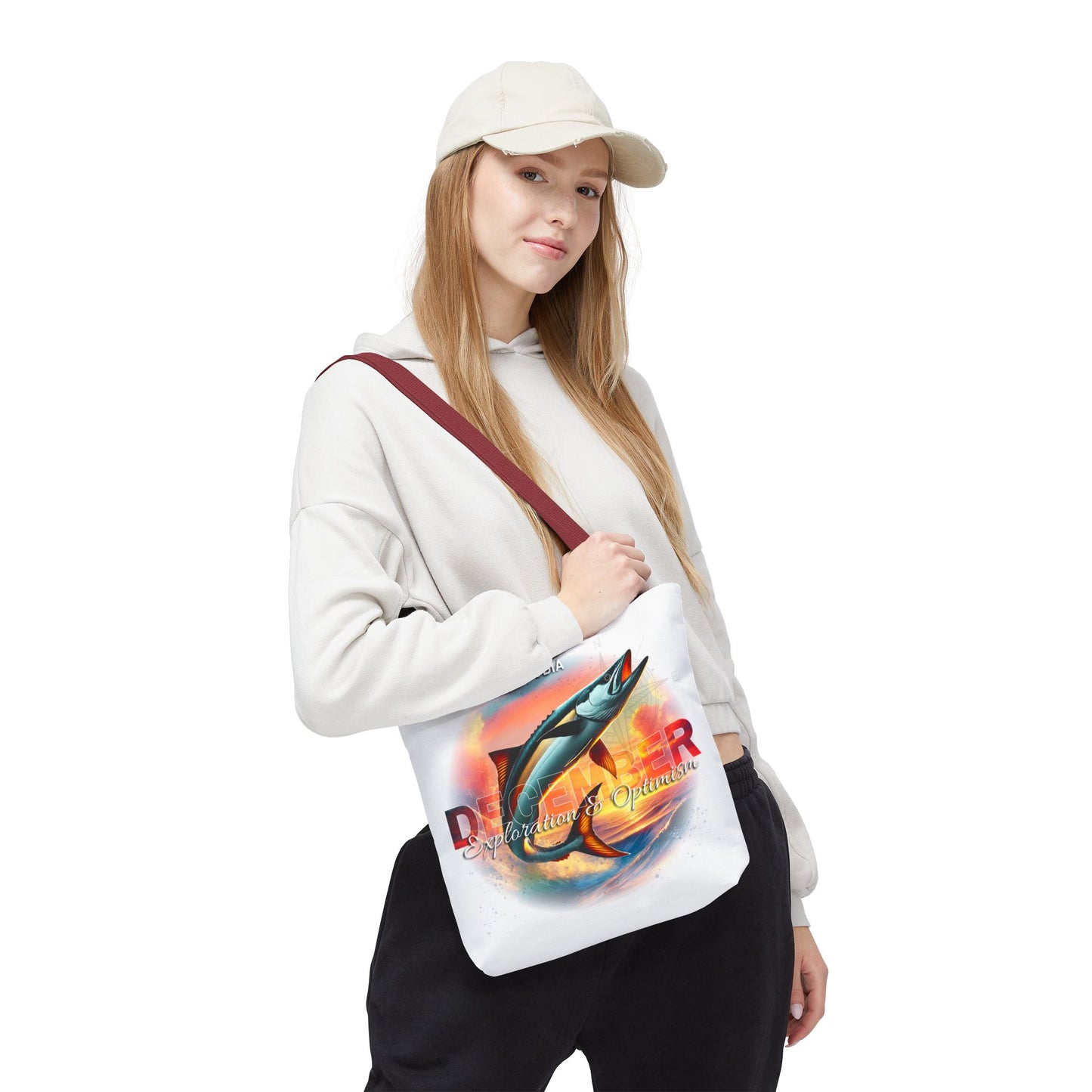 Woman wearing a white birth month beach tote with a marlin fish and vibrant sunset design