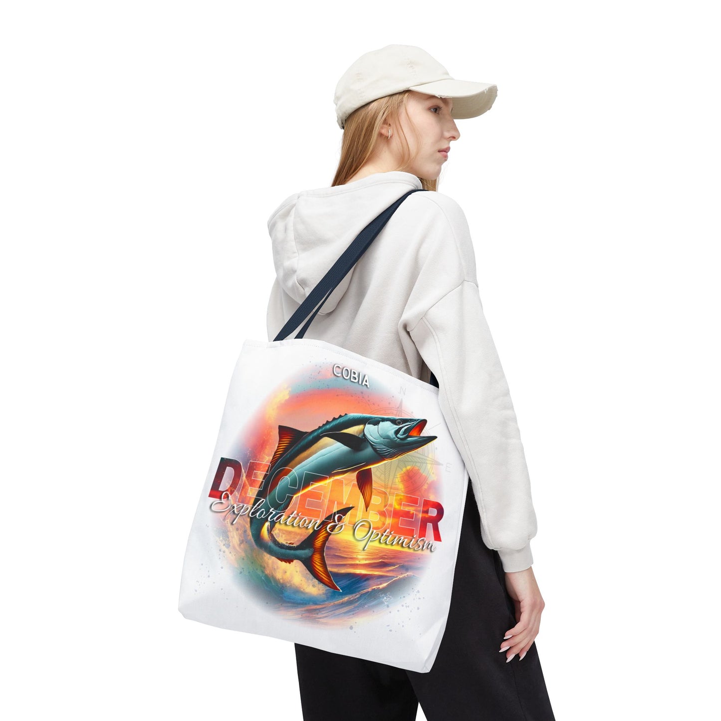 Birth month beach tote with colorful fish and ocean design worn by woman in white hoodie and cap