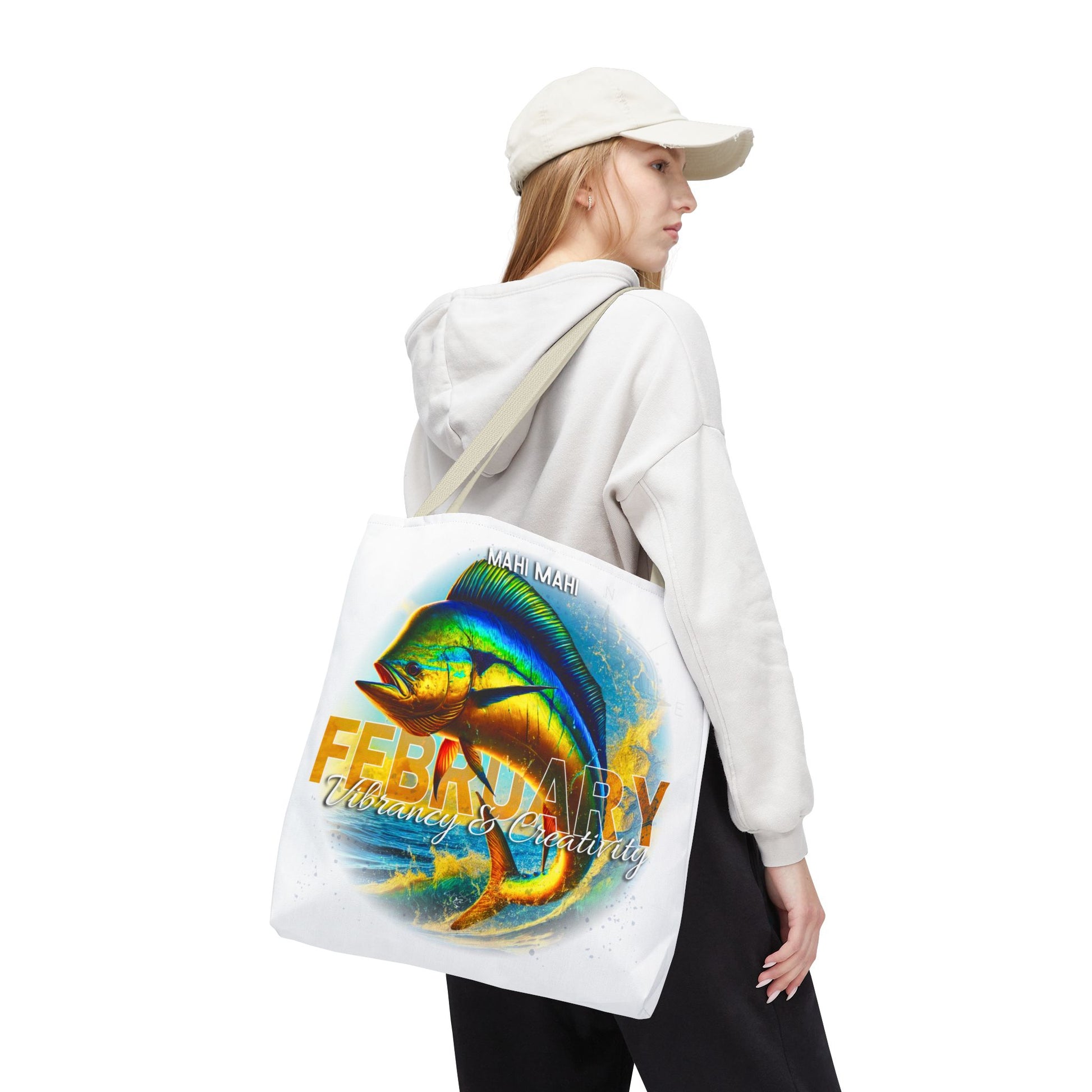 Birth month beach tote with colorful February fish design worn by woman in white hoodie and cap