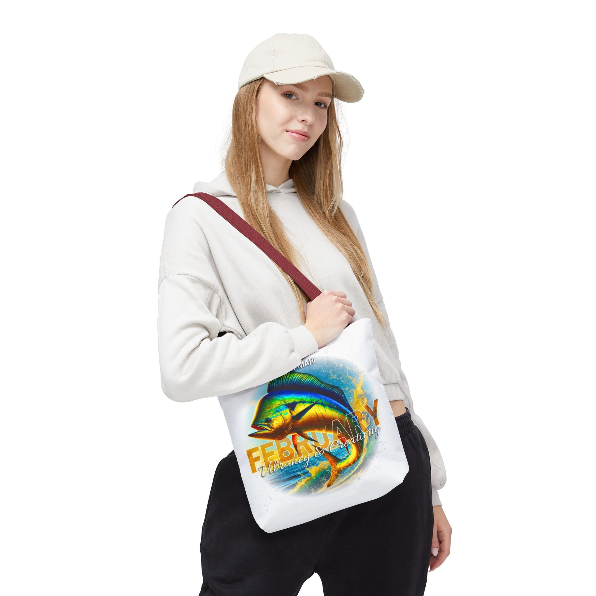 Woman wearing a white birth month beach tote with colorful fish design and February text