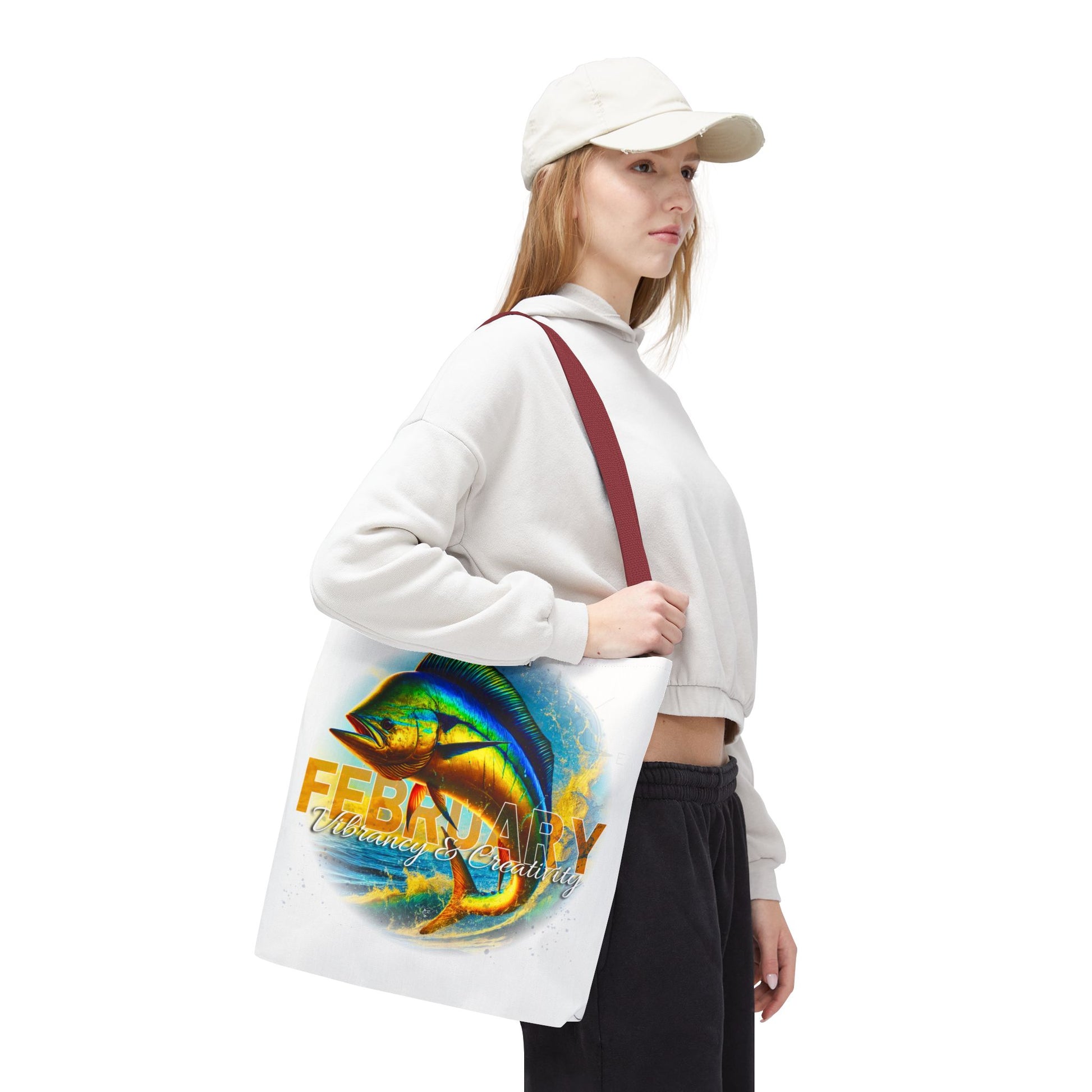 Woman carrying birth month beach tote with colorful February fish design and maroon straps