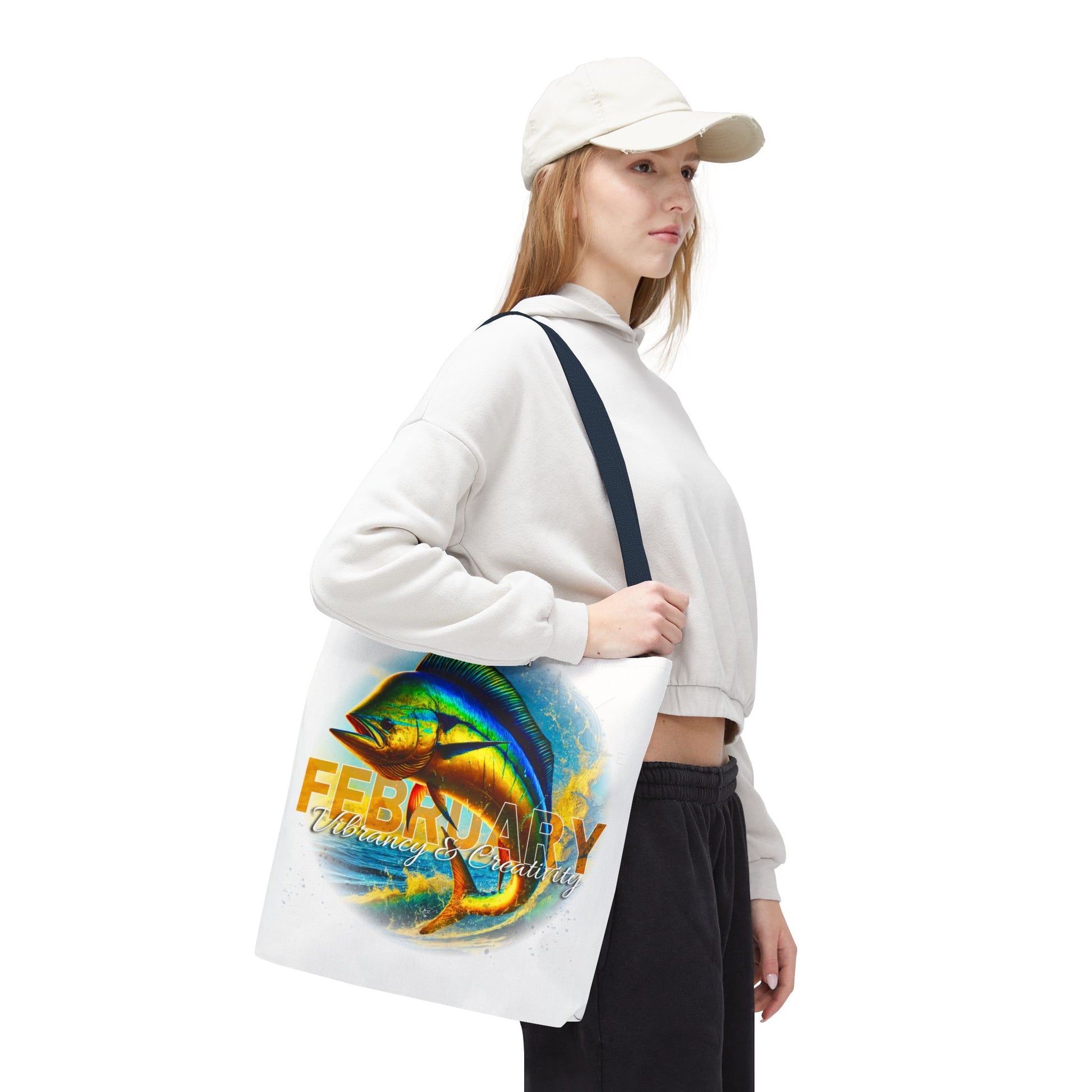 Woman wearing a white cap holding a birth month beach tote with colorful February fish design