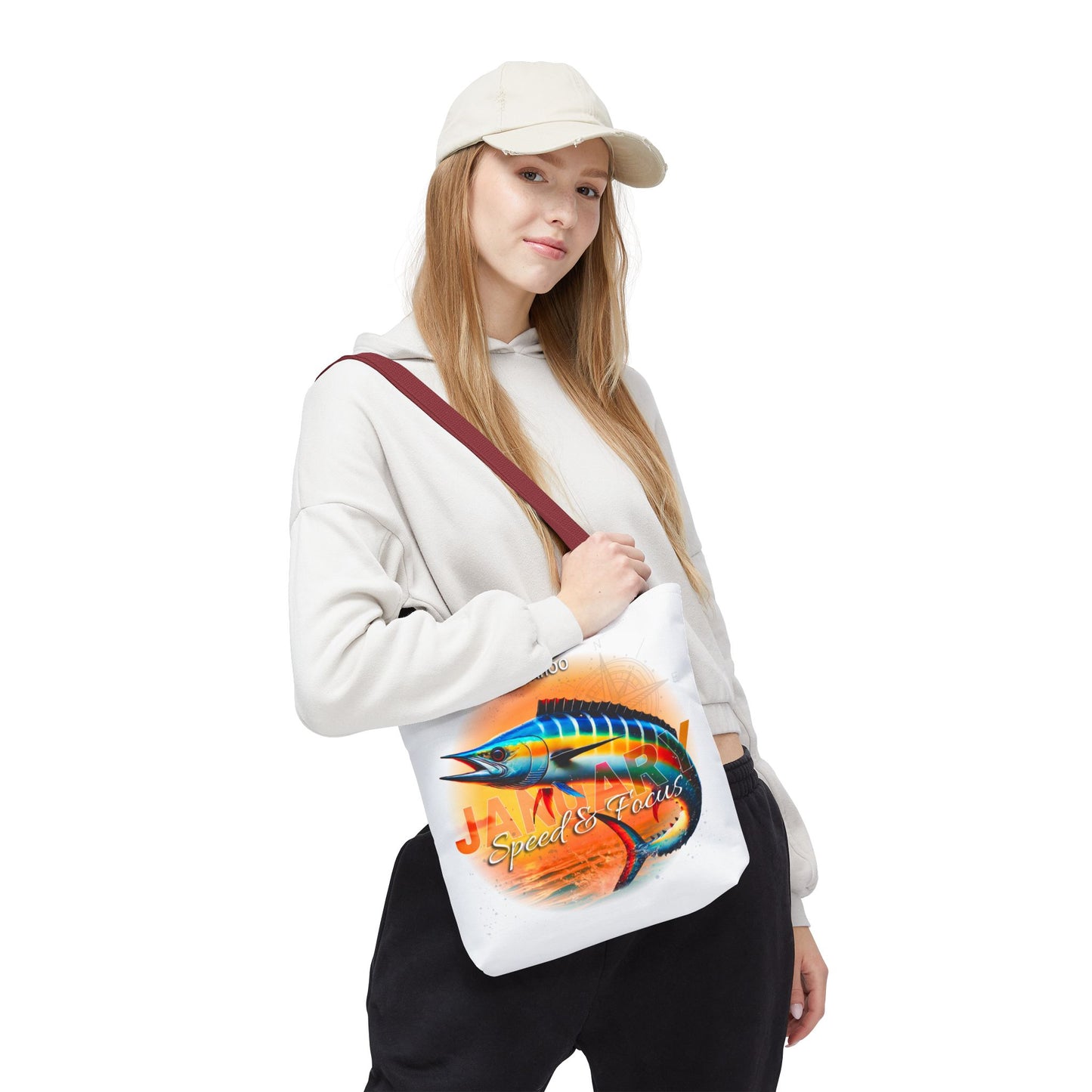 Woman wearing a white birth month beach tote with colorful fish design and red strap
