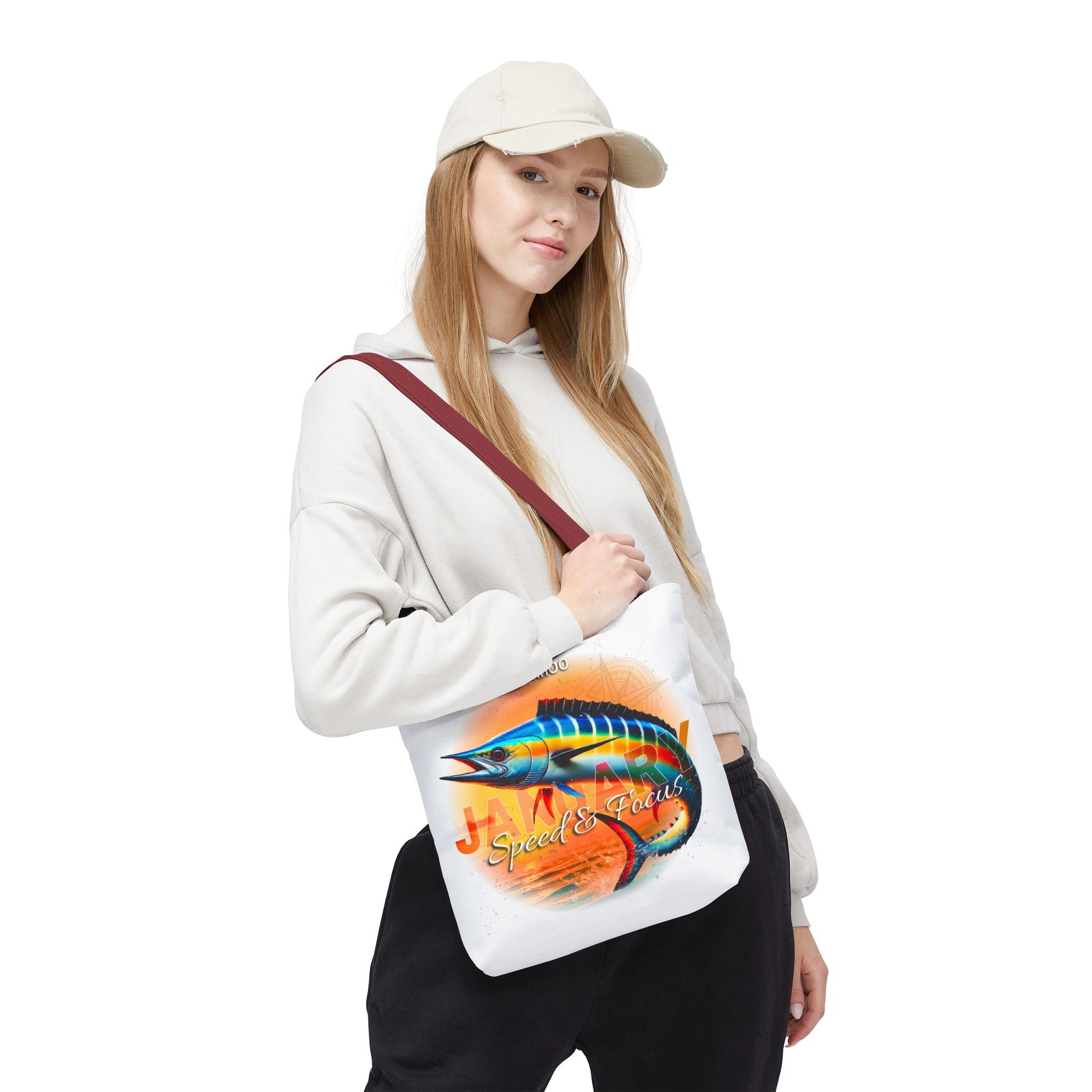 Woman wearing a white birth month beach tote with colorful fish design and red strap