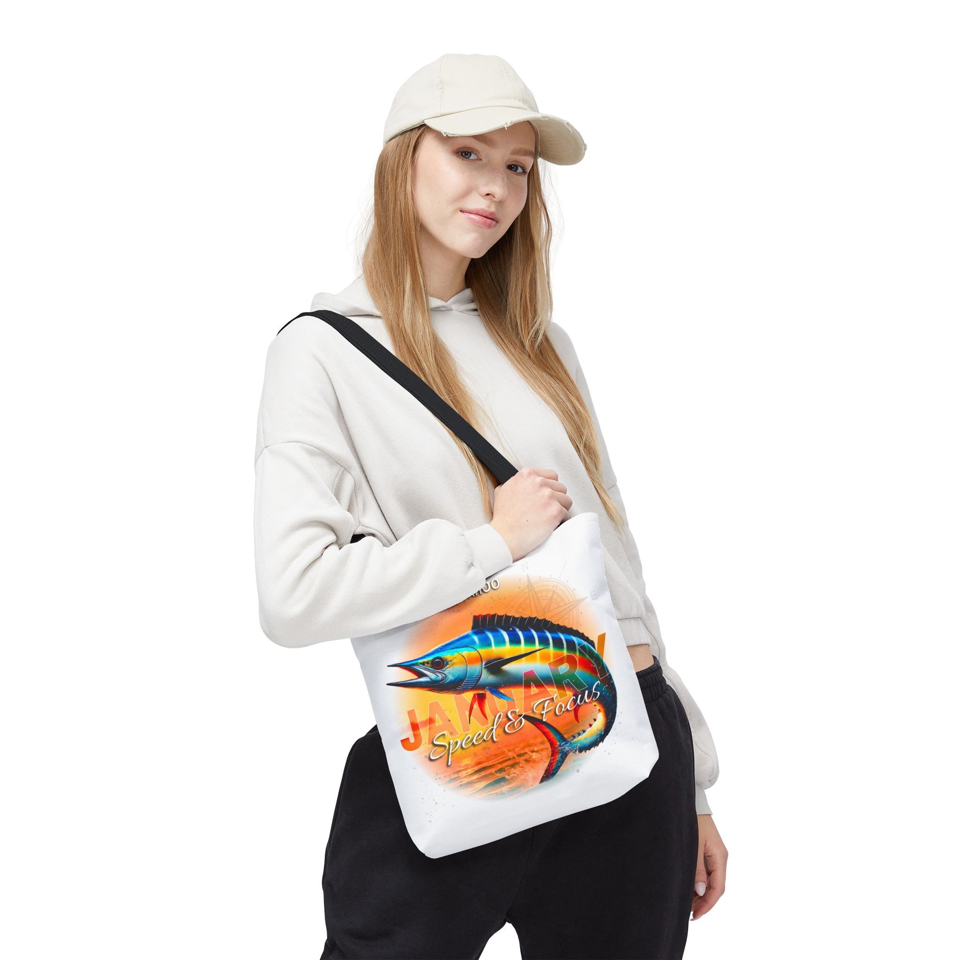 Woman wearing a white birth month beach tote with colorful fish design and black strap