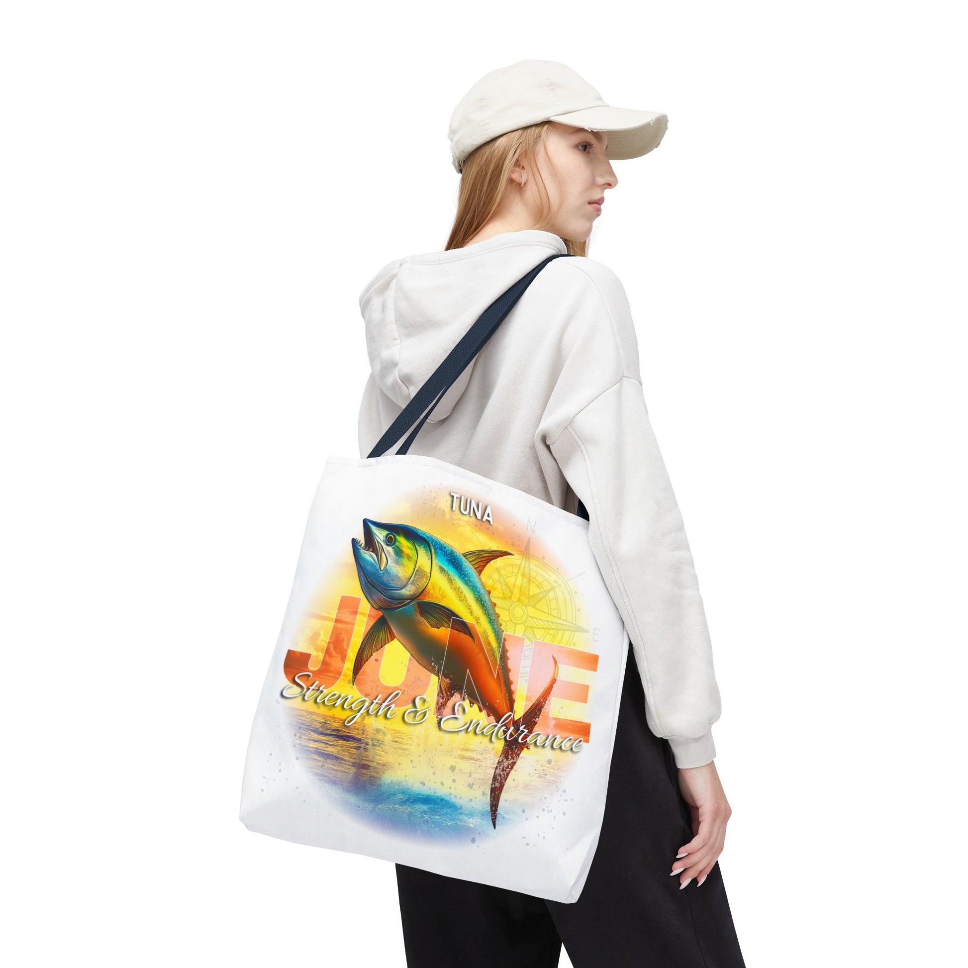 Birth month beach tote with colorful tuna fish design worn by woman in white hoodie and cap