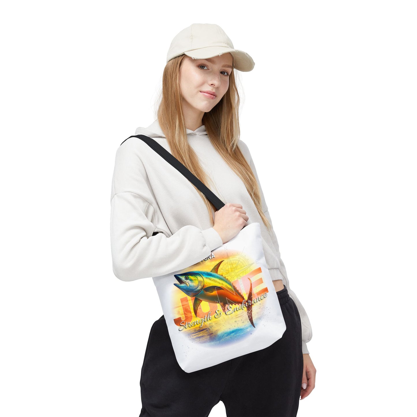 Woman wearing a white birth month beach tote with colorful fish design and black strap
