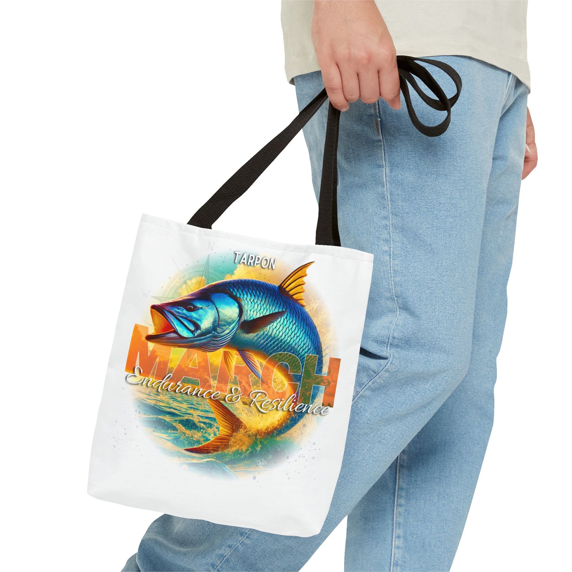Birth month beach tote with colorful tarpon fish design and black handles held by a person