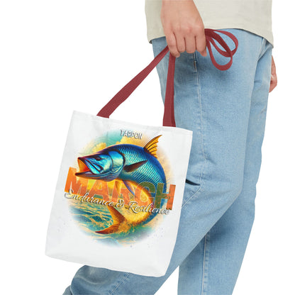 Birth month beach tote with blue tarpon fish design and red handles carried by person