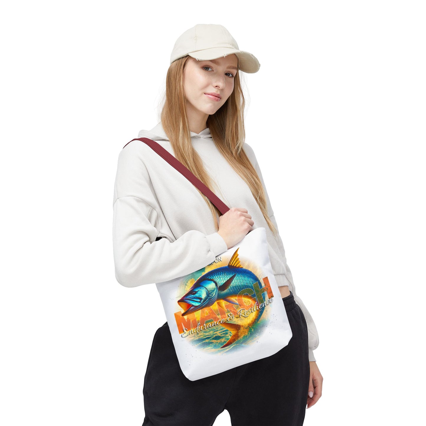 Woman wearing white birth month beach tote with colorful fish design and maroon strap