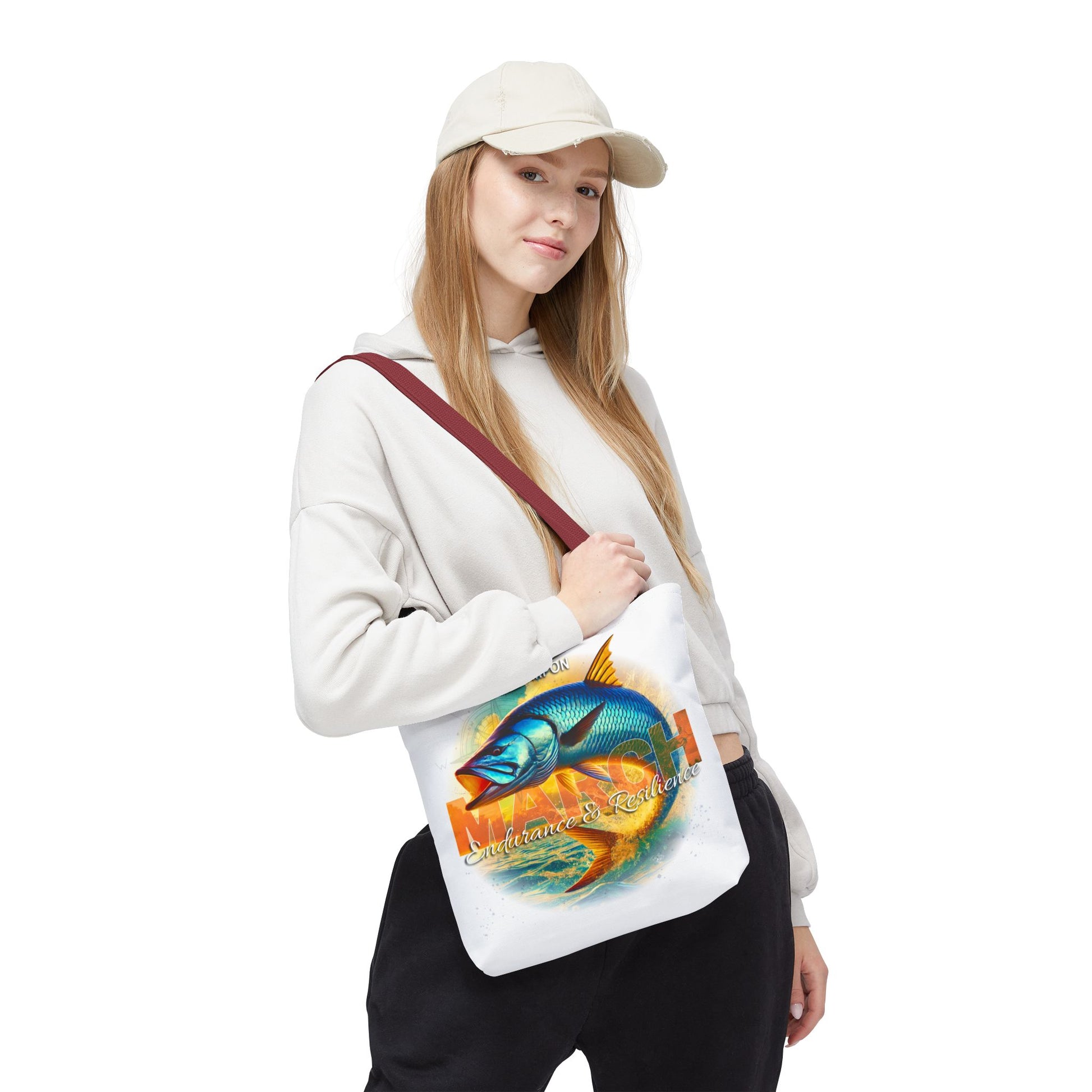Woman wearing white birth month beach tote with colorful fish design and maroon strap