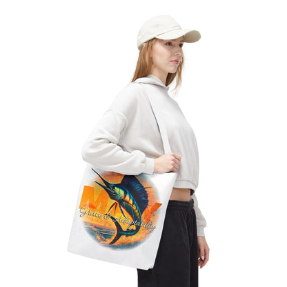 Woman wearing white hoodie and cap carrying birth month beach tote with colorful marlin design