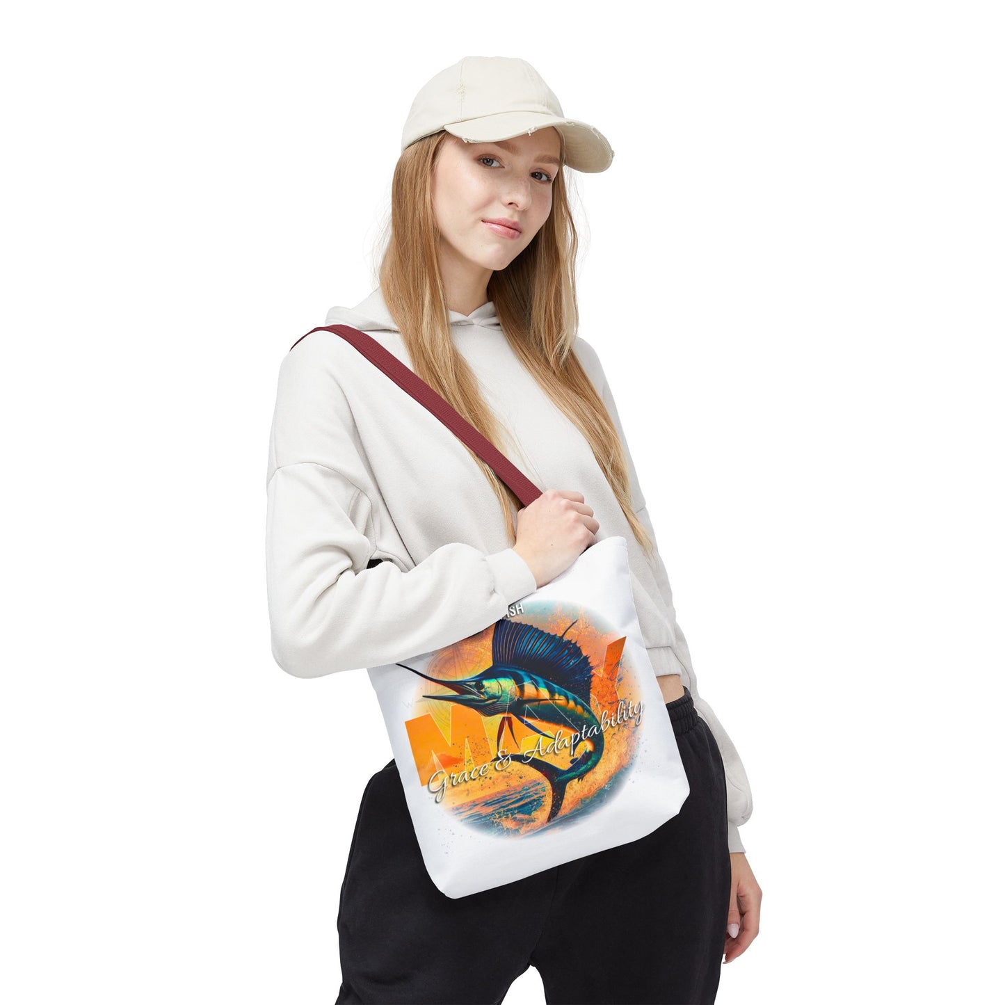 Woman wearing a white birth month beach tote with colorful fish design and maroon strap