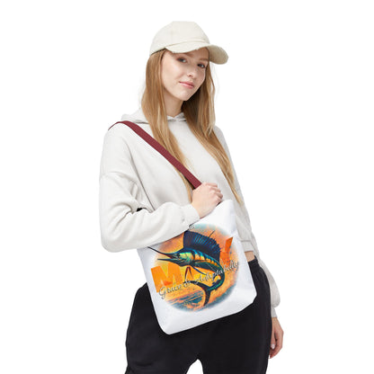 Woman wearing a white birth month beach tote with colorful fish design and maroon strap
