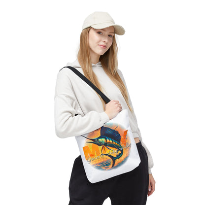 Woman wearing a white birth month beach tote with colorful fish design and black strap