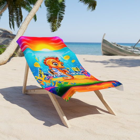 Colorful birth month kids beach towel with a playful sea horse design on a wooden beach chair by the ocean