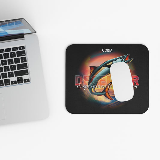 Birth month mouse pad with colorful fish design placed beside a laptop on white desk