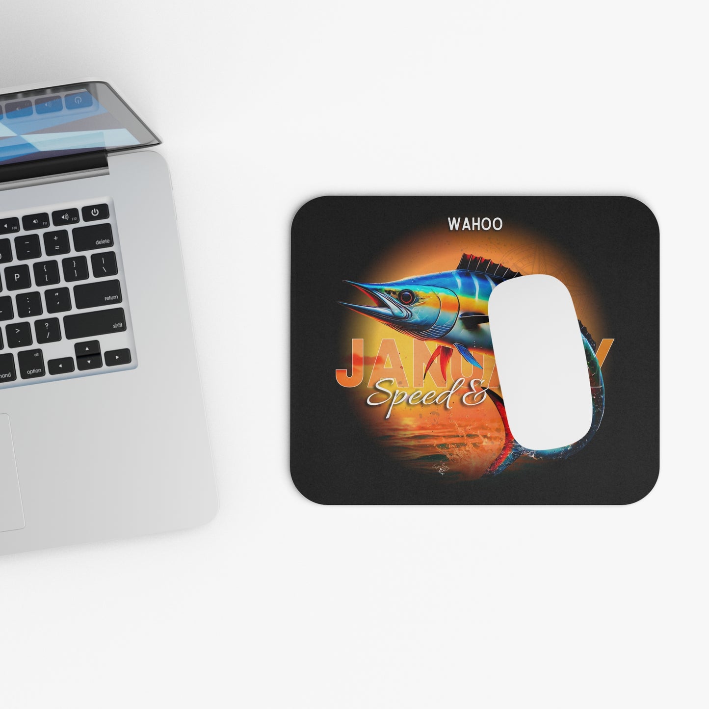 Wahoo print birth month mouse pad with colorful fish design next to laptop