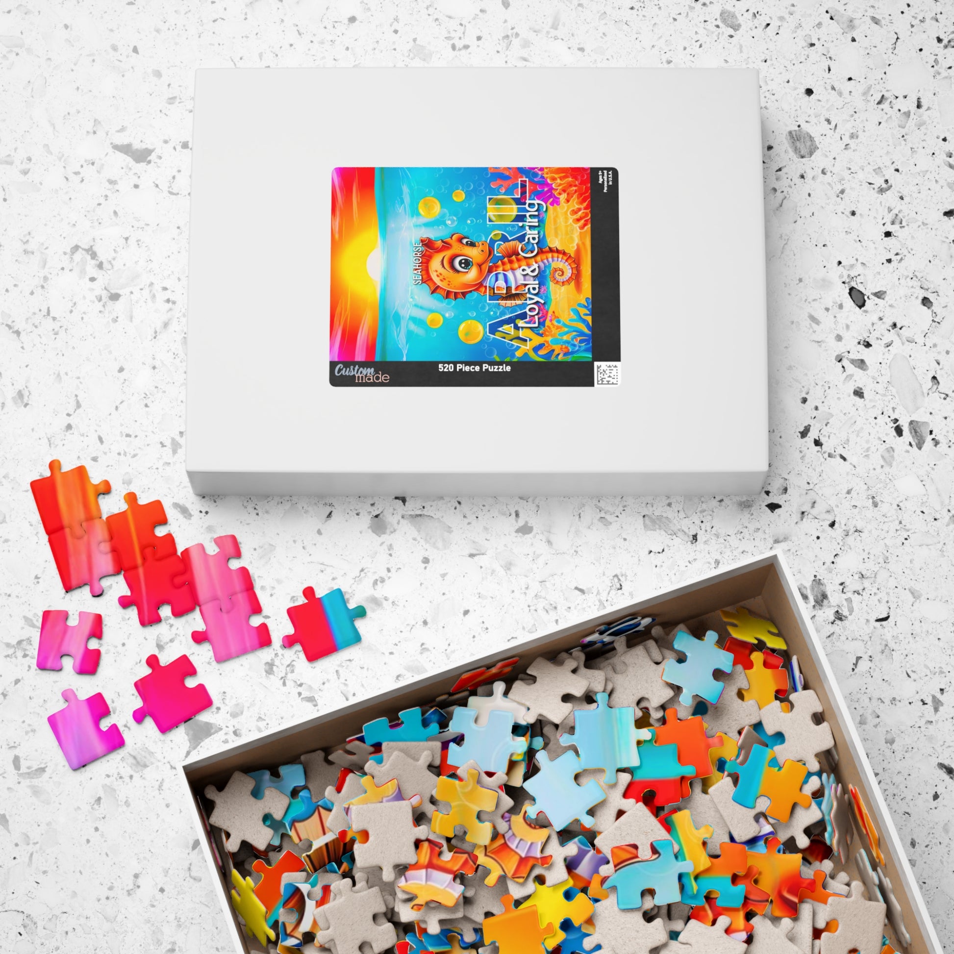 Kids birth month puzzle with colorful scattered pieces in an open white box on a speckled surface