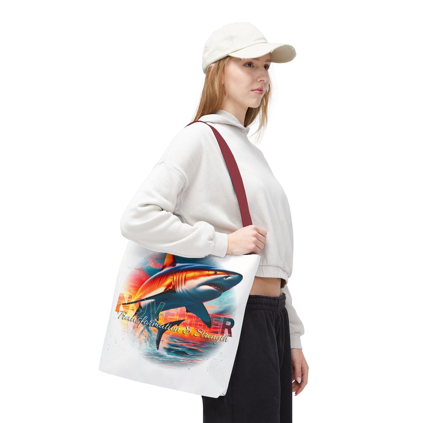 Birth month beach tote with colorful shark design carried by woman in white sweatshirt and cap
