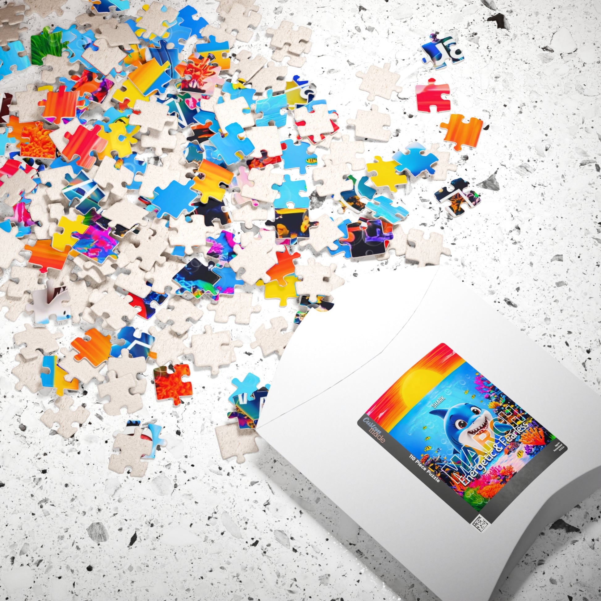 Kids birth month puzzle with colorful scattered pieces and white packaging on speckled surface
