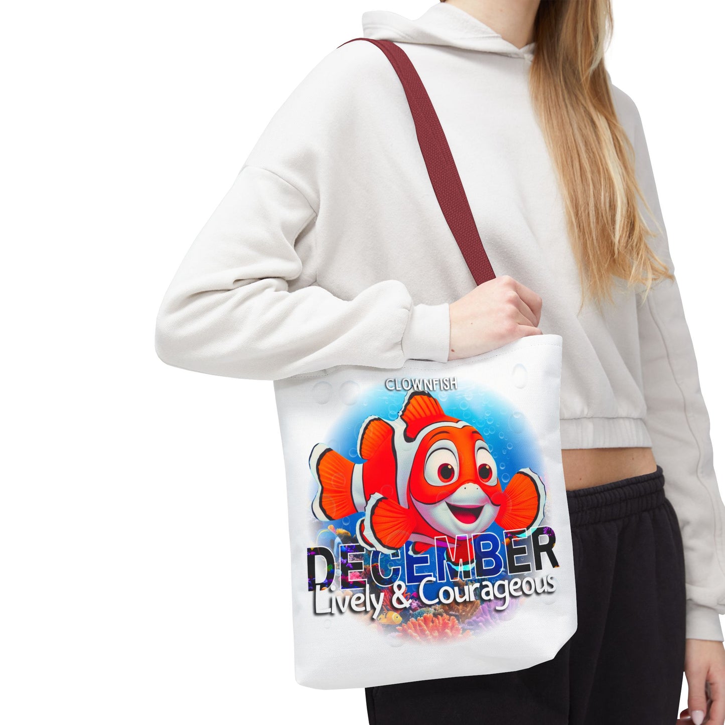 Kids birth month beach tote bag with colorful clownfish and December design carried by person