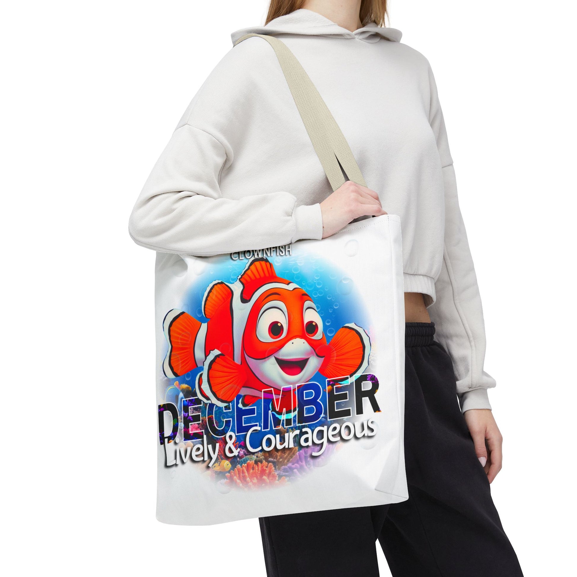 Kids birth month beach tote bag with colorful December clownfish design carried by person