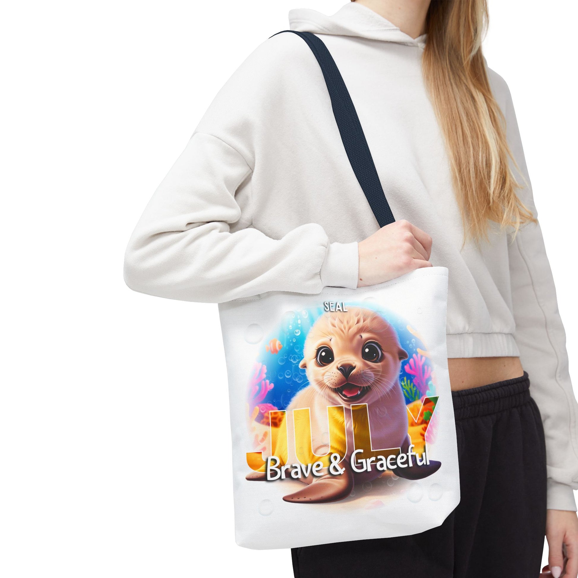 Kids birth month beach tote bag featuring a cute seal design with July and Brave & Graceful text