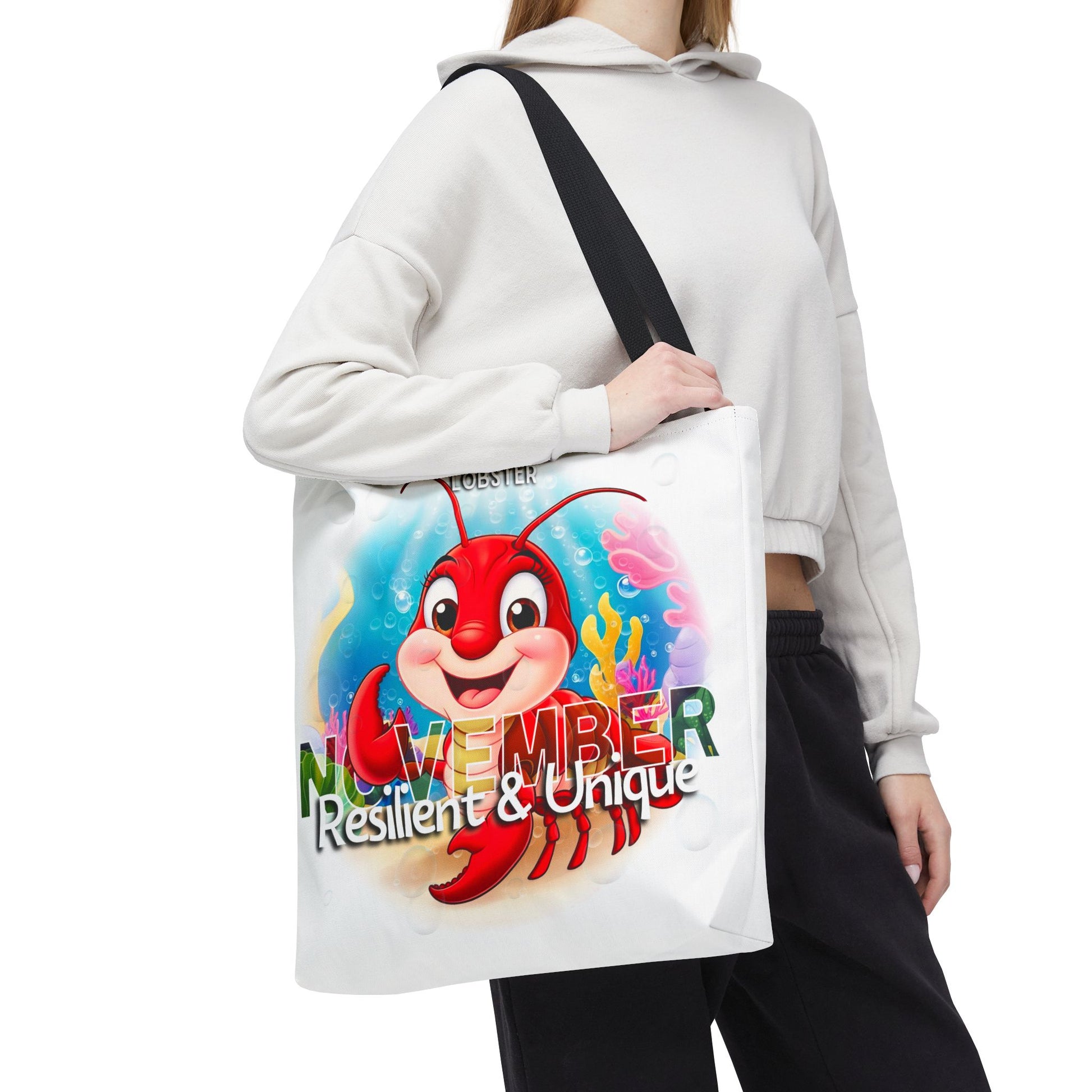 Birth month beach tote bag with colorful November design featuring a cheerful lobster and text resilient and unique