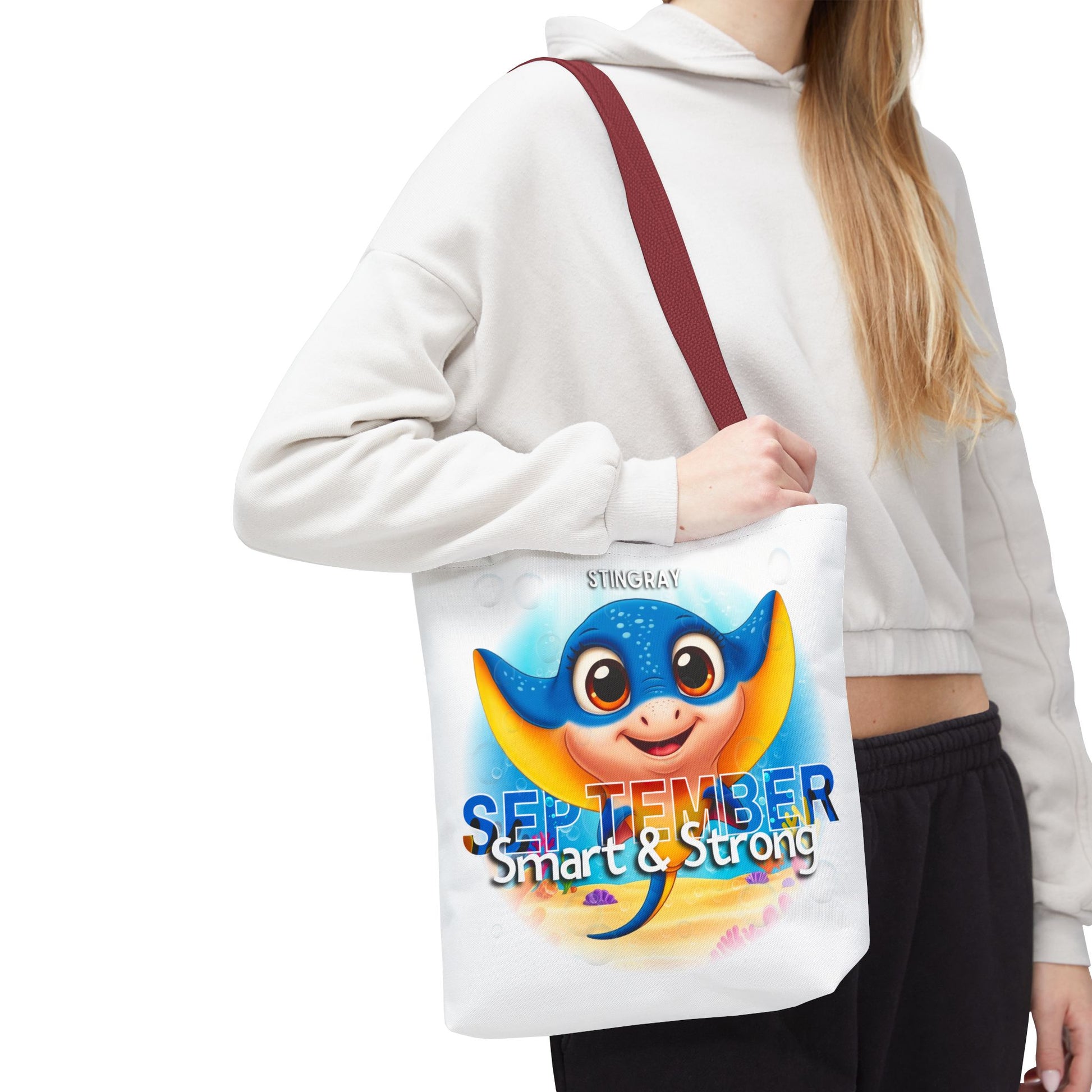 Kids birth month beach tote bag with stingray design and September text carried by person
