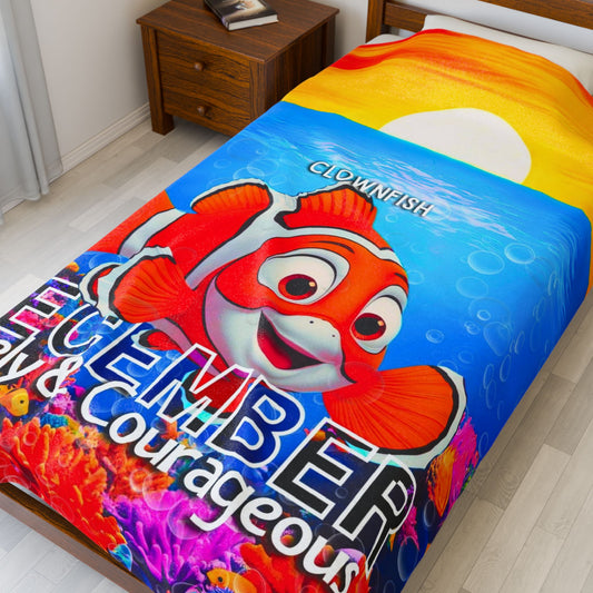 Colorful kids birth month blanket featuring a clownfish design and December text on a bed