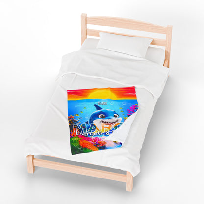 Kids birth month blanket with colorful shark design on a small wooden bed