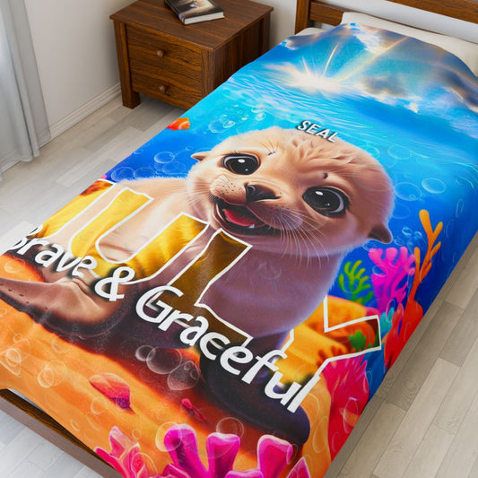 Kids birth month blanket featuring a cute seal with colorful underwater coral design on a bed