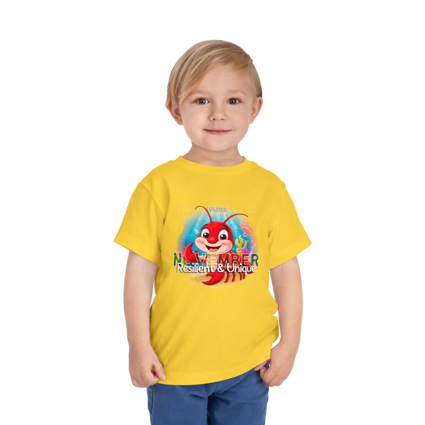 Child wearing a yellow kids birth month tshirt with a red cartoon lobster and November text