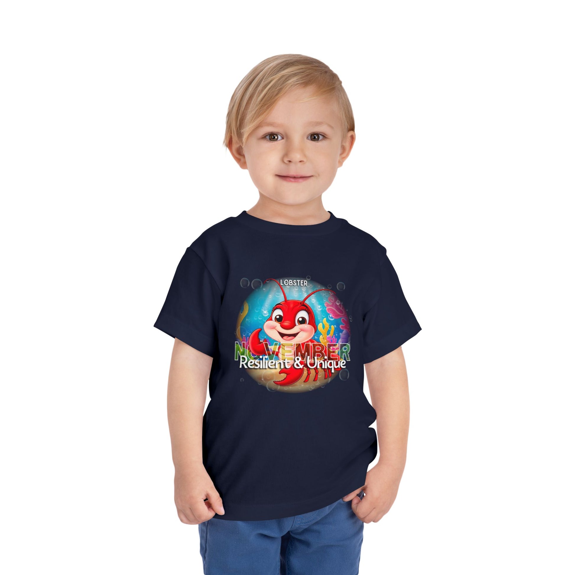 Child wearing navy kids birth month tshirt with November lobster design and Resilient Unique text