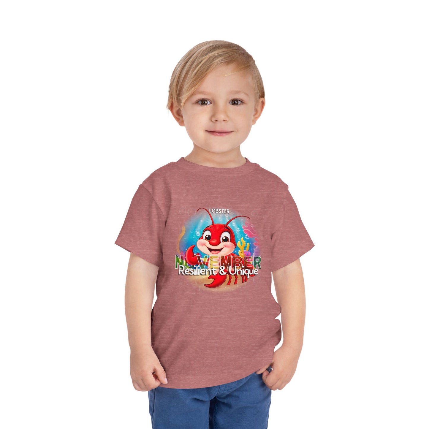 Young boy wearing a kids birth month tshirt with November lobster design in red