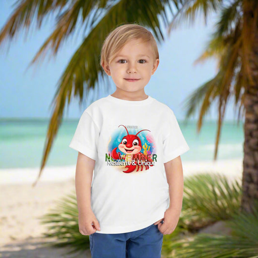 Toddler wearing a white kids birth month tshirt with November crab design standing on a beach