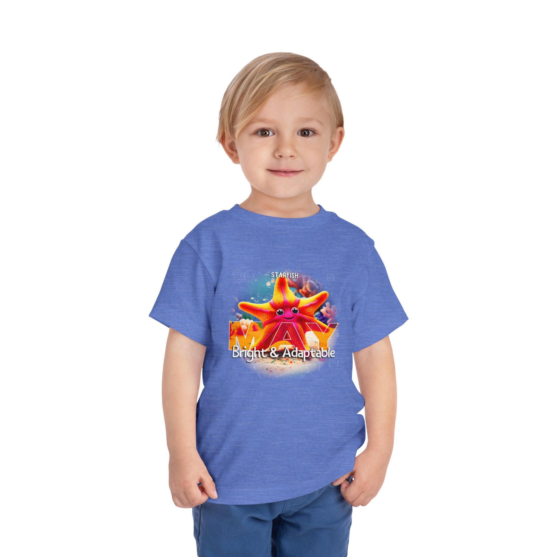 Kids birth month tshirt in blue with May starfish design worn by smiling young boy