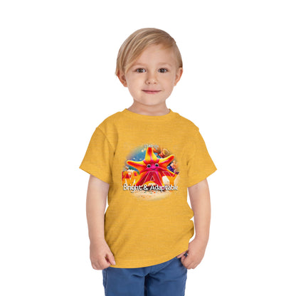 Toddler wearing a yellow kids birth month tshirt with colorful starfish design and text bright and adaptable