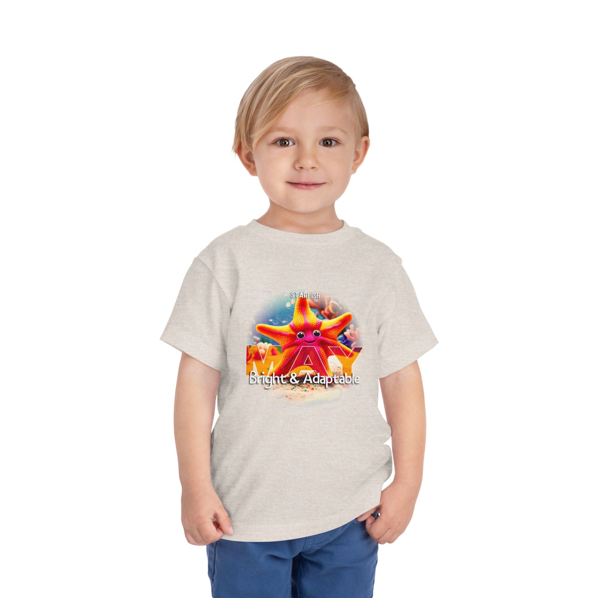 Kids birth month tshirt with May starfish design worn by young boy in blue shorts