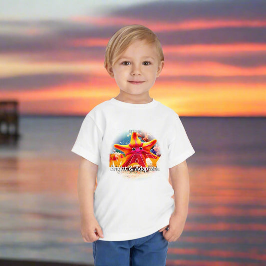 Young boy wearing kids birth month tshirt with colorful starfish design at sunset beach