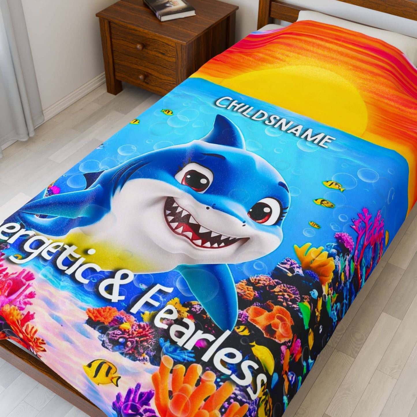 Colorful shark-themed kids blanket with coral and fish on a bed in a room.